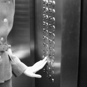 Femme appuyant sur le bouton de l'ascenseur